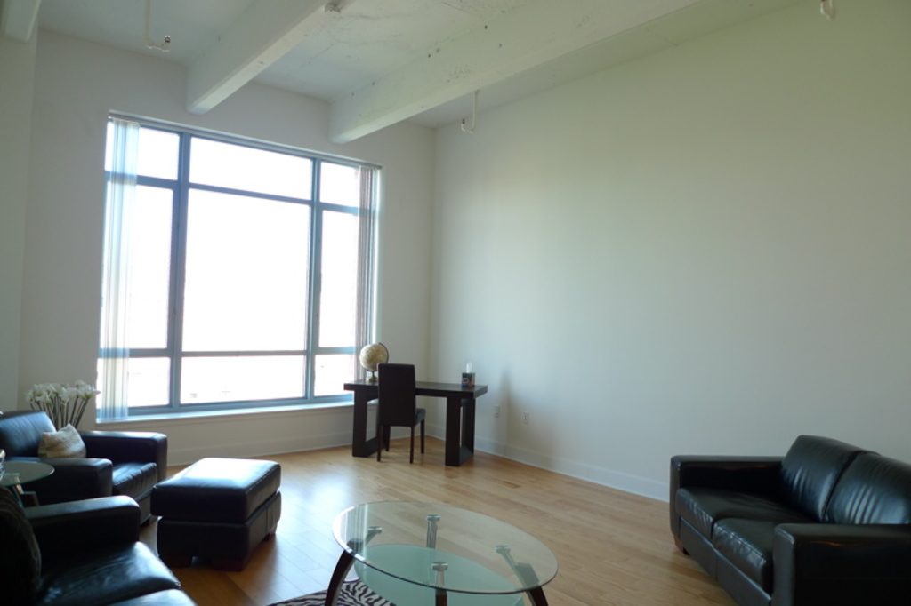 Bright open living room with tall windows and leather seating