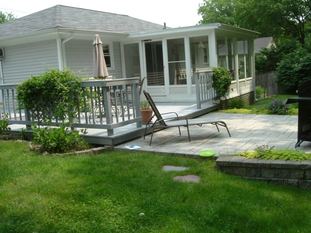 Backyard with a green lawn, deck, patio and screened porch